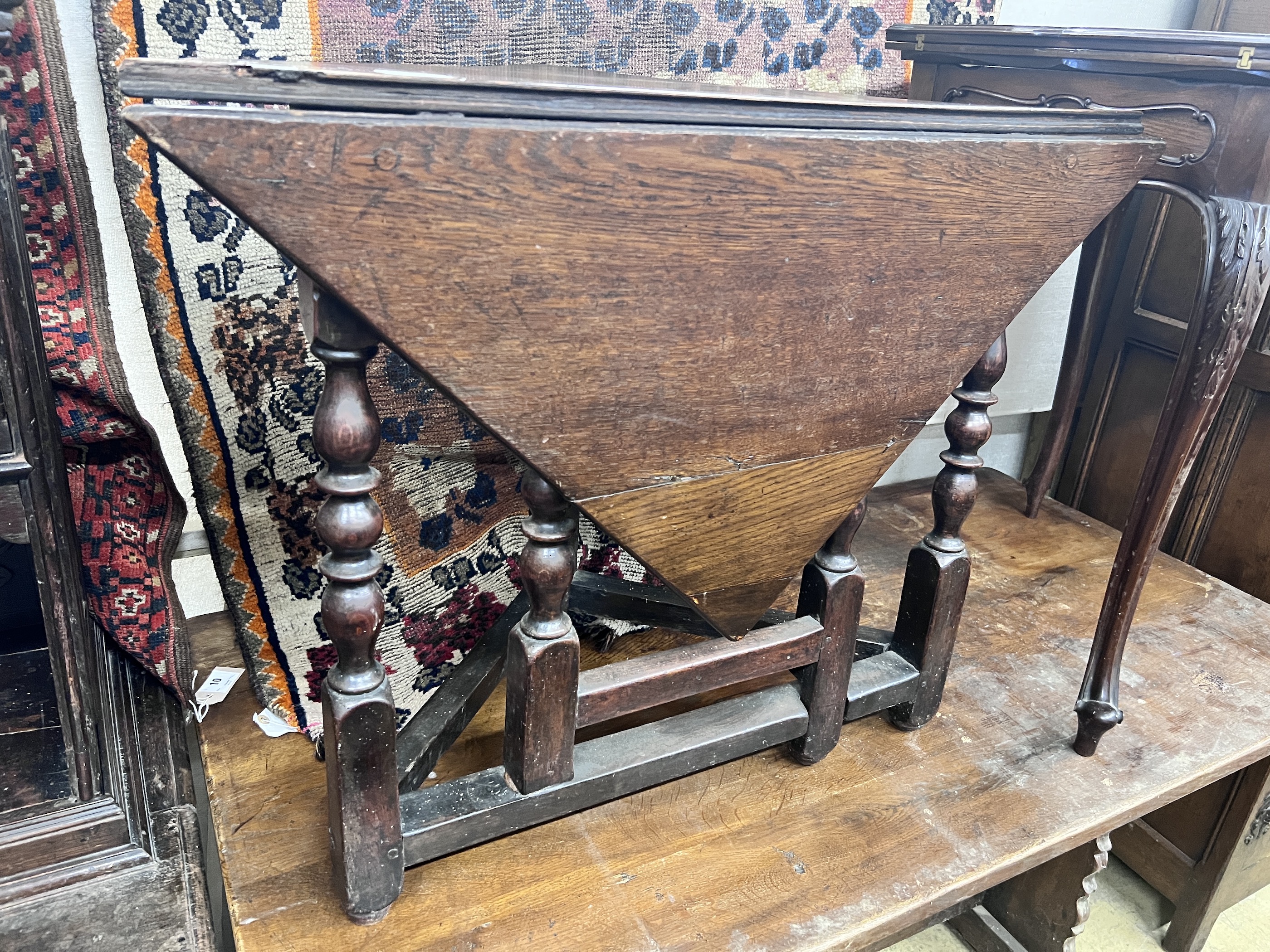 An 18th century oak triangular drop leaf table, width 86cm, depth 45cm, height 69cm